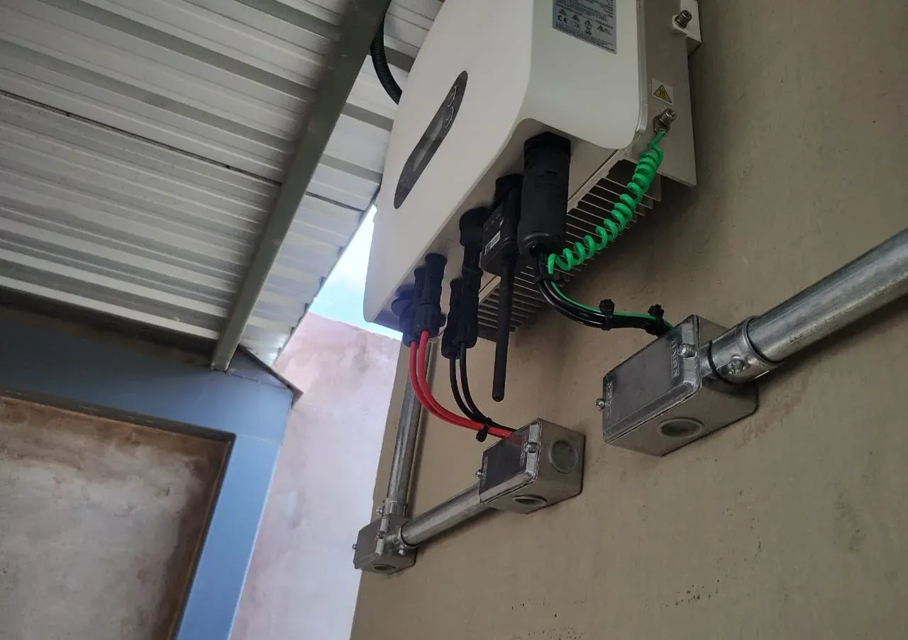 Conexões de entrada e saída do inversor solar, com cabos presos e eletrodutos