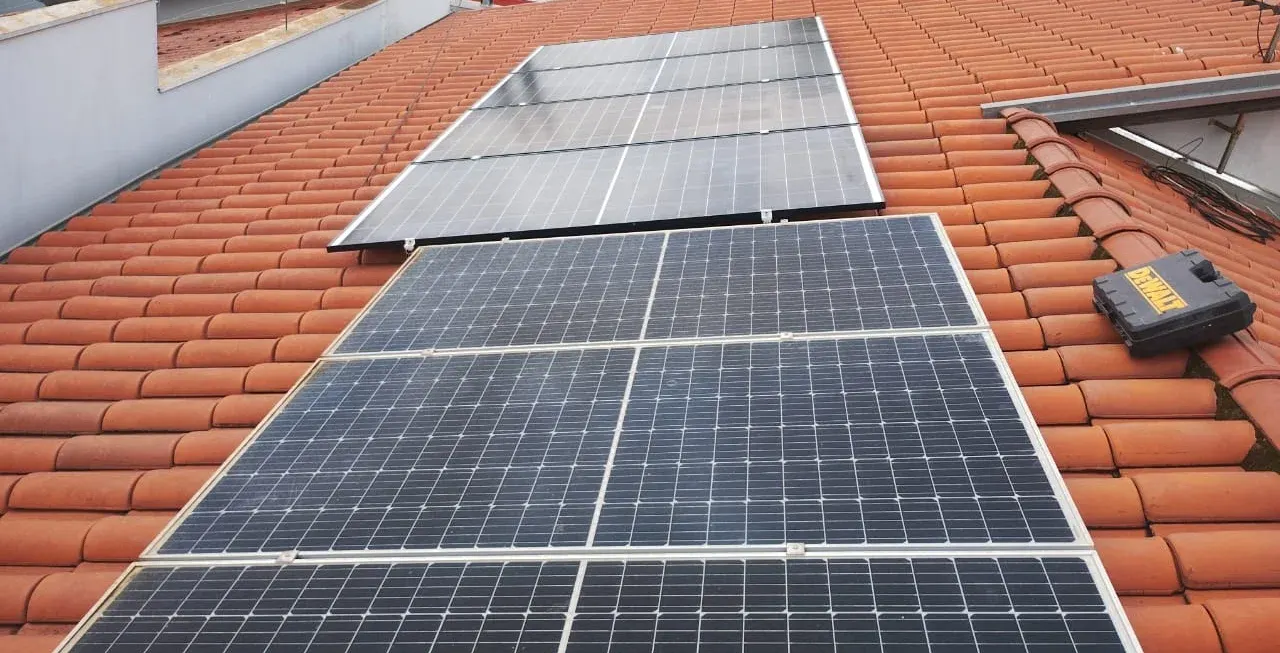 Painéis solares sobre telhado colonial, com um segundo arranjo logo abaixo